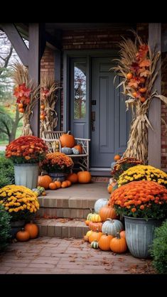 a porch decorated for fall with pumpkins and cornstatches on the steps