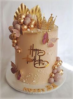 a birthday cake is decorated with gold and pink decorations on it's top tier