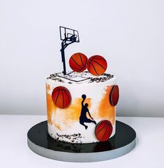 a birthday cake decorated with basketballs and a person jumping up into the air for a dunk