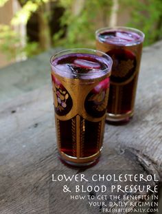 two glasses filled with liquid sitting on top of a wooden table next to each other