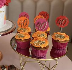 cupcakes with numbers on them sitting on a table next to other desserts