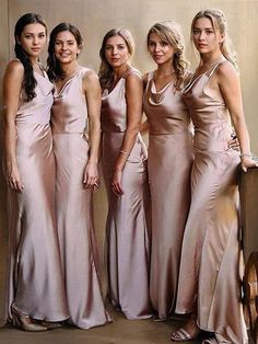 four beautiful women in long dresses posing for a photo