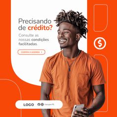 a man with dreadlocks and an orange shirt is smiling while holding a cell phone