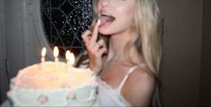 a woman is blowing out candles on her birthday cake