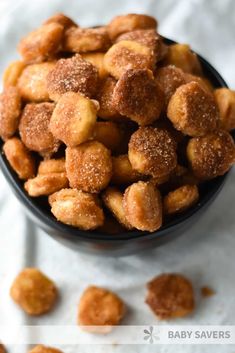 a bowl filled with sugared donuts on top of a table