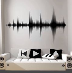 a white couch sitting in front of a wall with sound waves on it's side