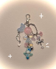 a key chain with various charms attached to it on a white surface and cross marks in the background