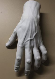 a close up of a white hand on a brown wall with no one around it