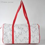 a white and red bag with deer print on the front is sitting against a wall