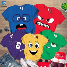 four t - shirts with different faces on them and one has an eyeball in the middle