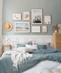 a bedroom with blue walls and pictures on the wall above the bed in front of it