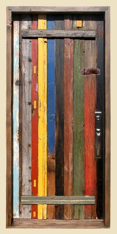 a wooden bench sitting in front of a multicolored wall