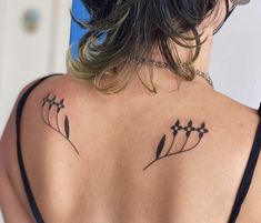 the back of a woman's shoulder with tattoos on it