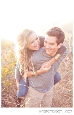 a man and woman are hugging in the grass