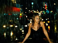 a woman standing in the rain at night