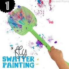 a hand holding a green plastic fan with the words fly swatter painting on it