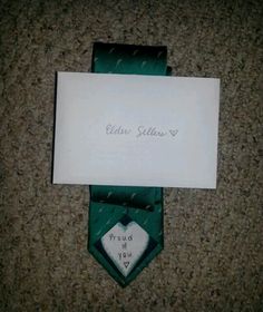 a green tie with a name tag on it and a note attached to the neck