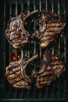 steaks being grilled on the grill with flames