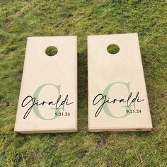 two personalized cornhole boards laying on the grass