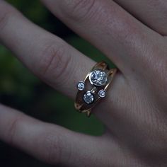 a woman's hand with a gold ring and two diamond rings on her fingers