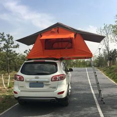 an orange tent attached to the back of a white car