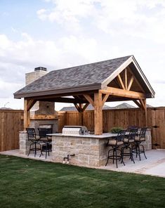 an outdoor kitchen and grill area in a backyard