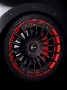 the front wheel of a sports car with red spokes