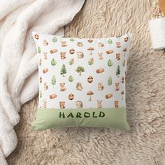 a throw pillow with woodland animals on it and the word harold written in green ink