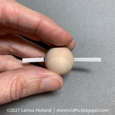 a person is holding a small ball on a stick