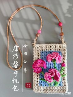 a crocheted purse with flowers on it and a cord hanging from the handle