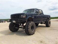 a large black truck parked on top of a parking lot