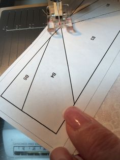 someone is cutting out the pattern on top of a piece of paper that has been sewn