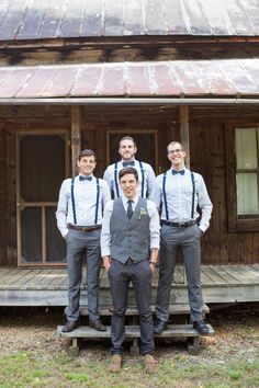 a group of young men standing next to each other in front of a wooden building