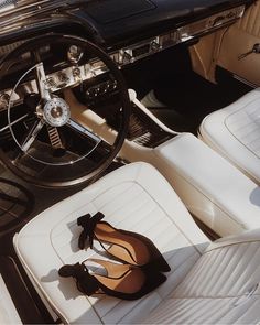 a woman's shoes are sitting on the floor in front of an old car