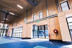 the inside of a large building with lots of windows and blue carpeted flooring