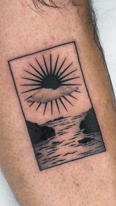 a man with a tattoo on his arm that has the sun above water in it