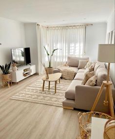 a living room filled with furniture and a flat screen tv on top of a wooden table