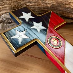 a wooden cross with stars painted on it and the colors of red, white, and blue