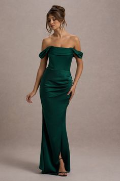 a woman in a green dress posing for the camera with her hands on her hips