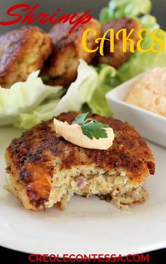 crab cakes on a plate with lettuce and sauce