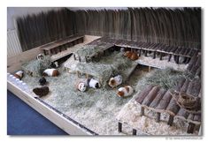 there are many small animals in the caged area with hay and straw on the floor