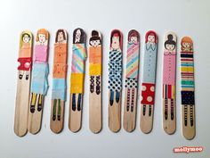 six wooden skis with different designs and people on them, lined up in a row