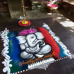 an elephant is painted on the ground in front of a building with flowers and candles