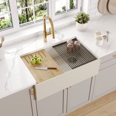 a kitchen sink with two apples on the cutting board