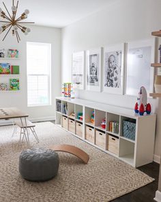 a child's playroom with toys, bookshelves and pictures on the wall