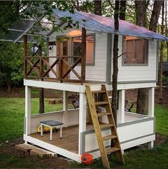 a tree house with a ladder to the roof and stairs leading up to the second floor