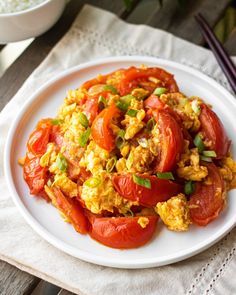 a white plate topped with tomatoes and scrambled eggs