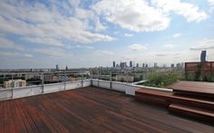 a wooden deck with benches on it and the city skyline in the backround