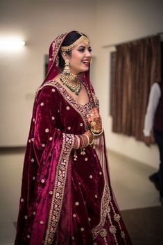 a woman in a red and gold bridal outfit