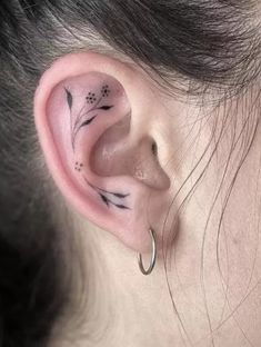 a woman's ear with flowers and leaves on the inside of her left ear